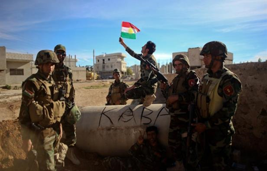 YPG militias wave a Kurdish flag in Kobane, 27 January 2015 - Photo Credit: Hosam Katan for Reuters