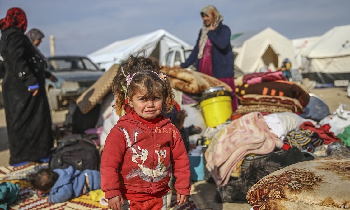 A Syrian girl who fled the attacks of Syrian and Russian air forces, cries as her family shelters at tents at the Turkish-Syrian border. Photo credit: Anadolu Agency/Getty Images